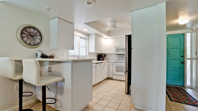 kitchen featuring white cabinetry, white appliances, sink, and light tile patterned floors