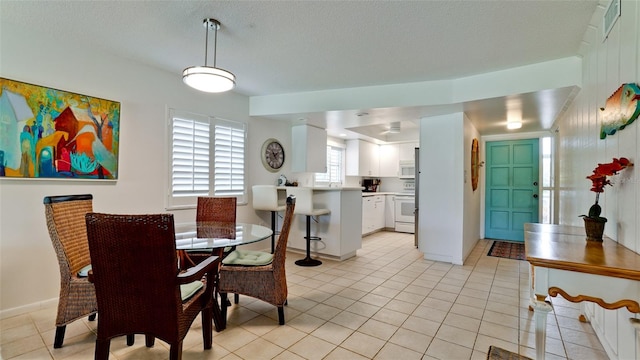 tiled dining area featuring a textured ceiling