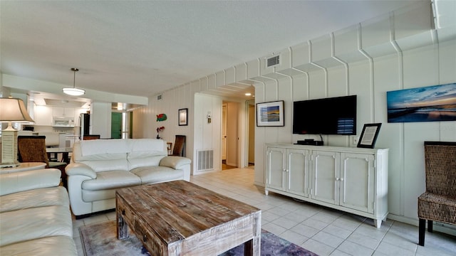 living room featuring light tile patterned floors and a textured ceiling