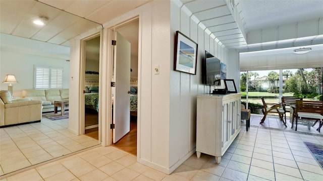 corridor with a wealth of natural light and light tile patterned flooring