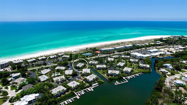 drone / aerial view with a water view and a beach view