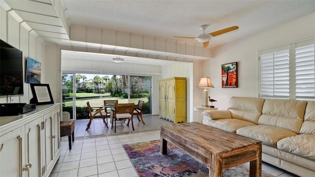 tiled living room featuring a textured ceiling and ceiling fan