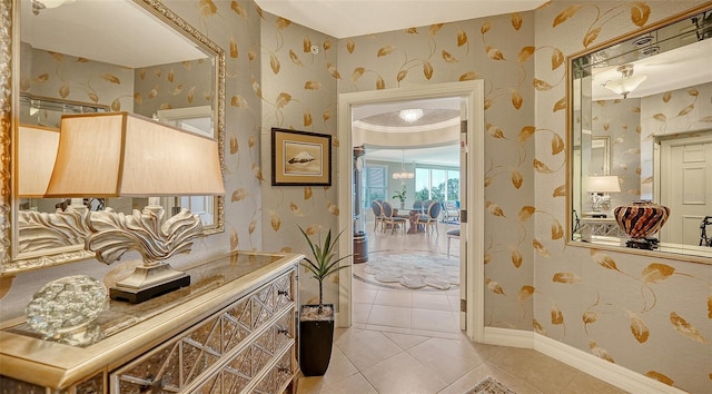 interior space with tile patterned flooring, an inviting chandelier, crown molding, and vanity