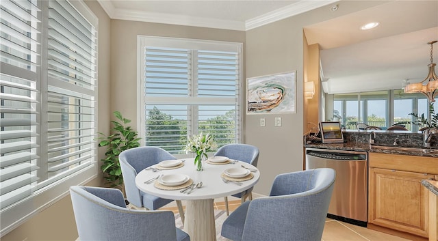 tiled dining area with a notable chandelier, crown molding, a wealth of natural light, and sink