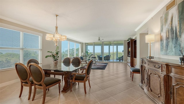 tiled dining room with ceiling fan with notable chandelier, ornamental molding, and a wealth of natural light