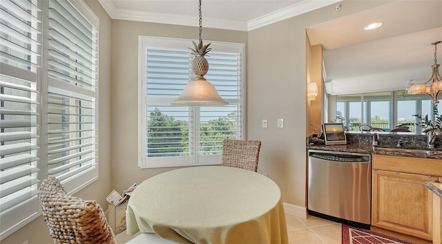 tiled dining space with a healthy amount of sunlight, an inviting chandelier, crown molding, and sink