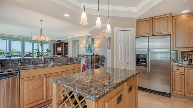 kitchen with dark stone counters, appliances with stainless steel finishes, a chandelier, and a center island