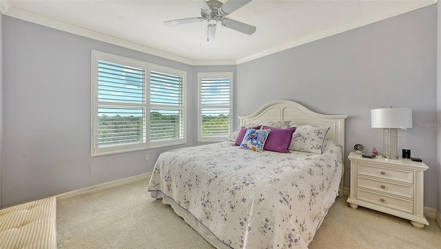 carpeted bedroom featuring ceiling fan and crown molding