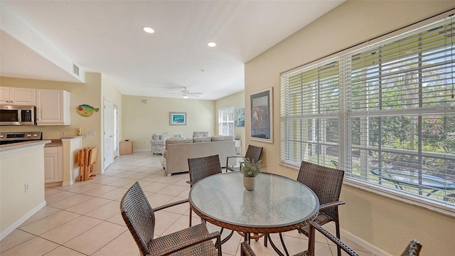 tiled dining room featuring a wealth of natural light and ceiling fan