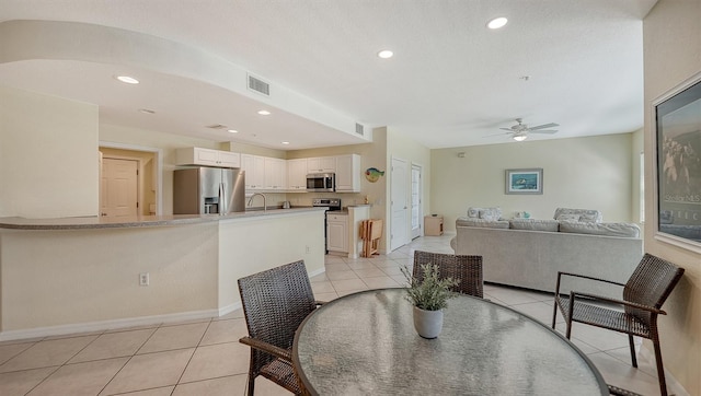 dining space with light tile flooring and ceiling fan