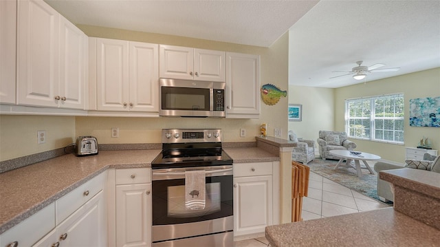 kitchen featuring white cabinetry, ceiling fan, and stainless steel appliances