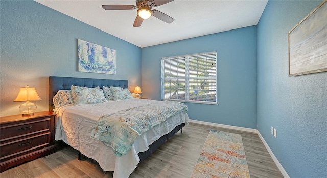 bedroom with ceiling fan and hardwood / wood-style flooring