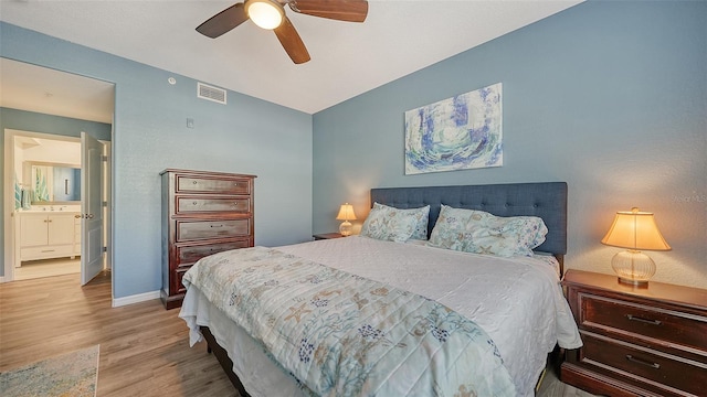 bedroom featuring ceiling fan, ensuite bath, and light hardwood / wood-style flooring