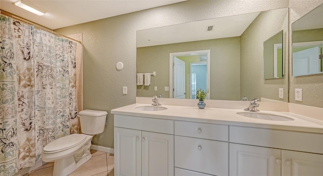 bathroom with tile floors, vanity with extensive cabinet space, toilet, and double sink