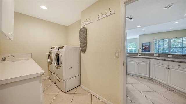 laundry room featuring cabinets, sink, washing machine and dryer, and light tile flooring