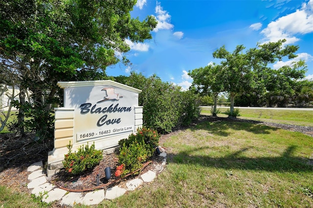 community sign featuring a lawn