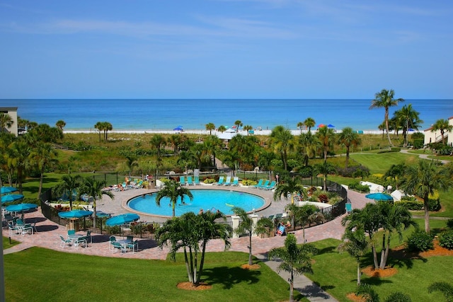 view of pool featuring a yard, a water view, and a patio area