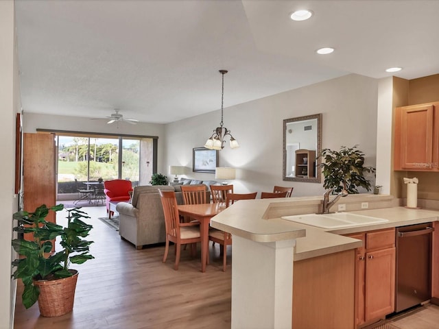 kitchen with ceiling fan with notable chandelier, sink, decorative light fixtures, dishwasher, and light hardwood / wood-style floors