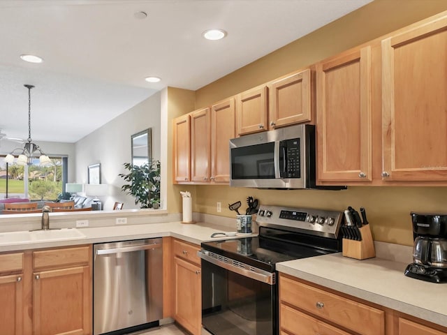 kitchen featuring light brown cabinetry, stainless steel appliances, sink, pendant lighting, and an inviting chandelier