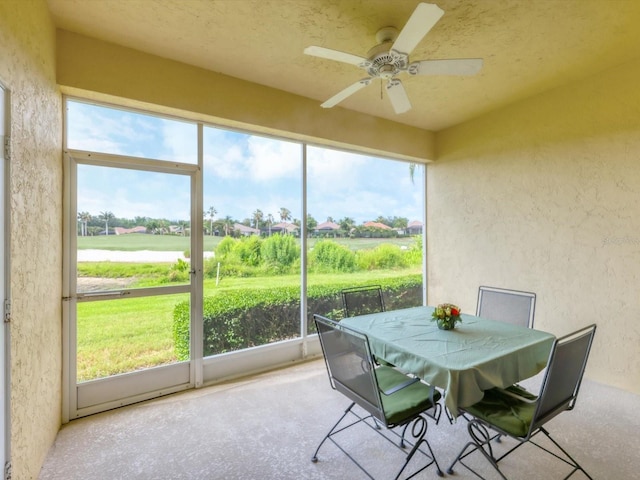 sunroom / solarium with ceiling fan and a rural view