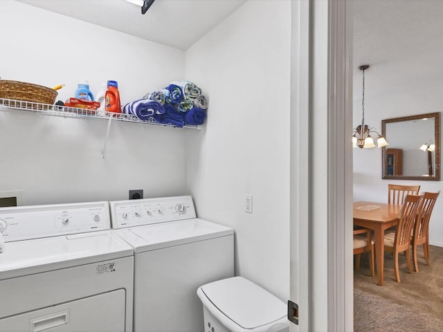 clothes washing area with washing machine and dryer, carpet floors, and an inviting chandelier