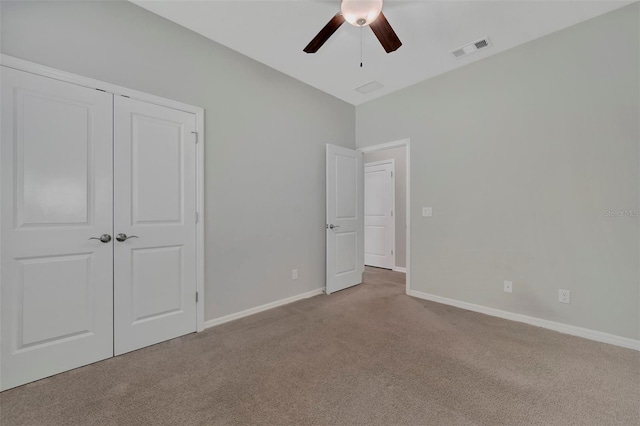 unfurnished bedroom with light colored carpet, ceiling fan, and a closet