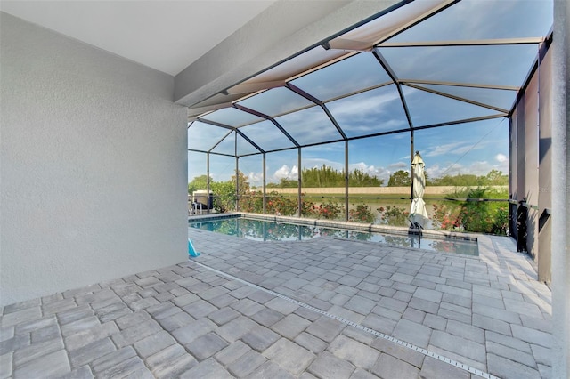 view of swimming pool featuring glass enclosure and a patio area