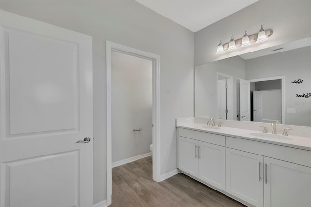 bathroom featuring wood-type flooring, vanity, and toilet