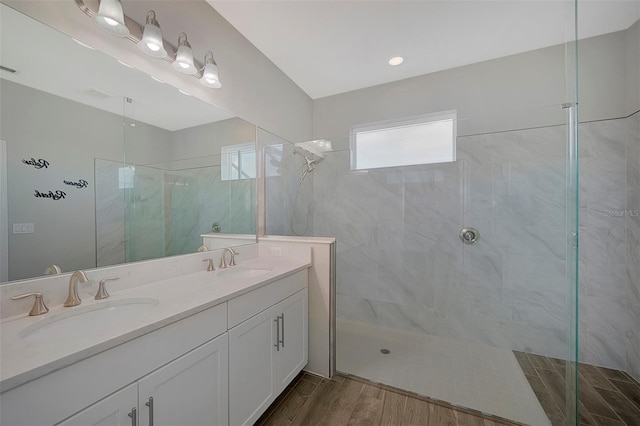 bathroom featuring tiled shower, vanity, and wood-type flooring