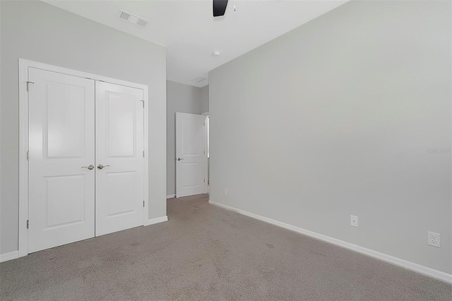 unfurnished bedroom with carpet, ceiling fan, and a closet