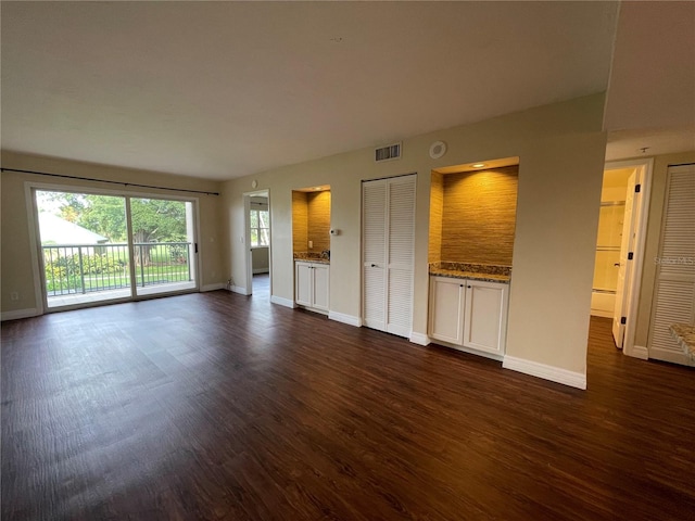 unfurnished living room with dark hardwood / wood-style flooring