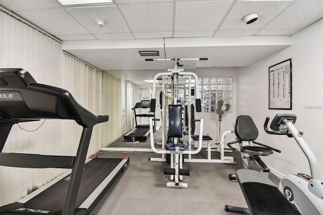 exercise area with concrete flooring and a paneled ceiling