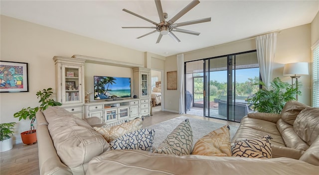 living room with ceiling fan and light hardwood / wood-style flooring