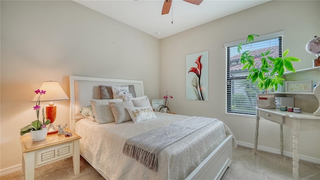 bedroom with multiple windows, ceiling fan, and light carpet