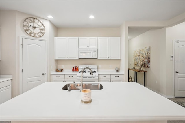 kitchen with white cabinetry, wood-type flooring, white appliances, and an island with sink