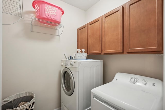 washroom featuring separate washer and dryer and cabinets