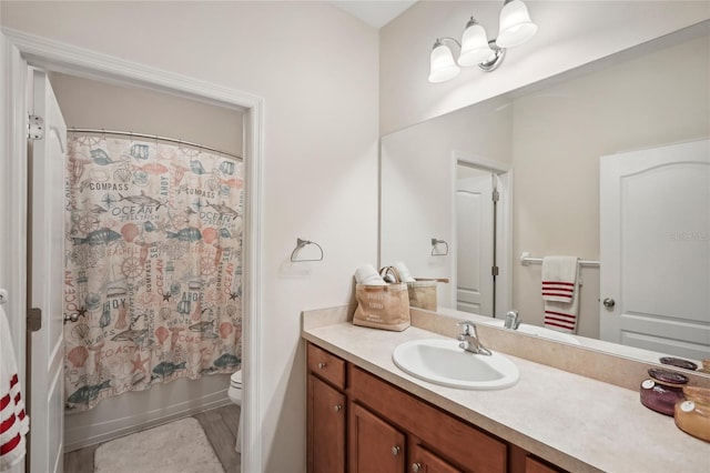 full bathroom featuring hardwood / wood-style floors, vanity, shower / bath combo, and toilet