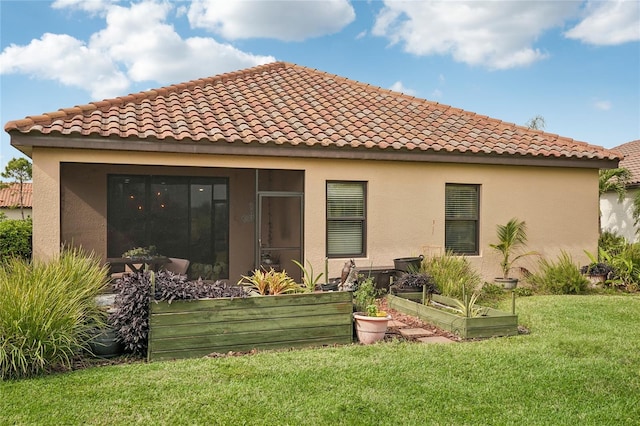 rear view of property featuring a sunroom and a yard