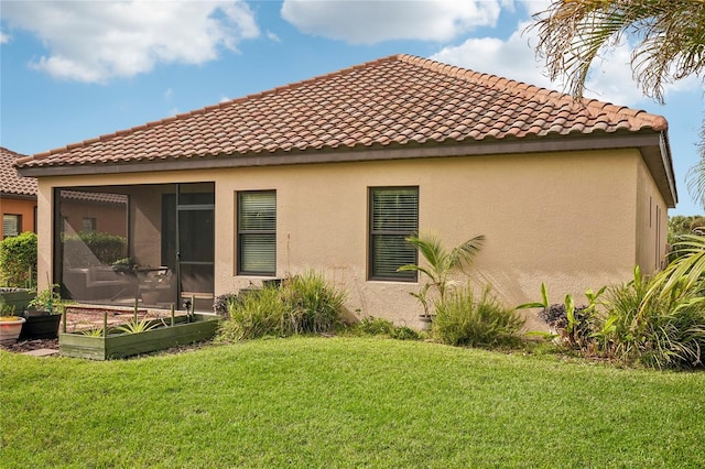 rear view of property featuring a sunroom and a yard