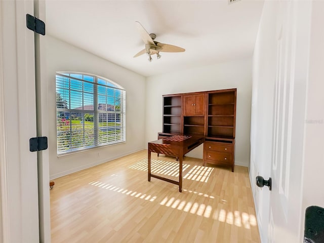 office area featuring baseboards, light wood-style flooring, and a ceiling fan