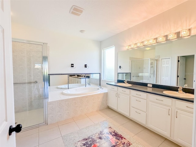 full bath with a bath, a sink, and tile patterned floors