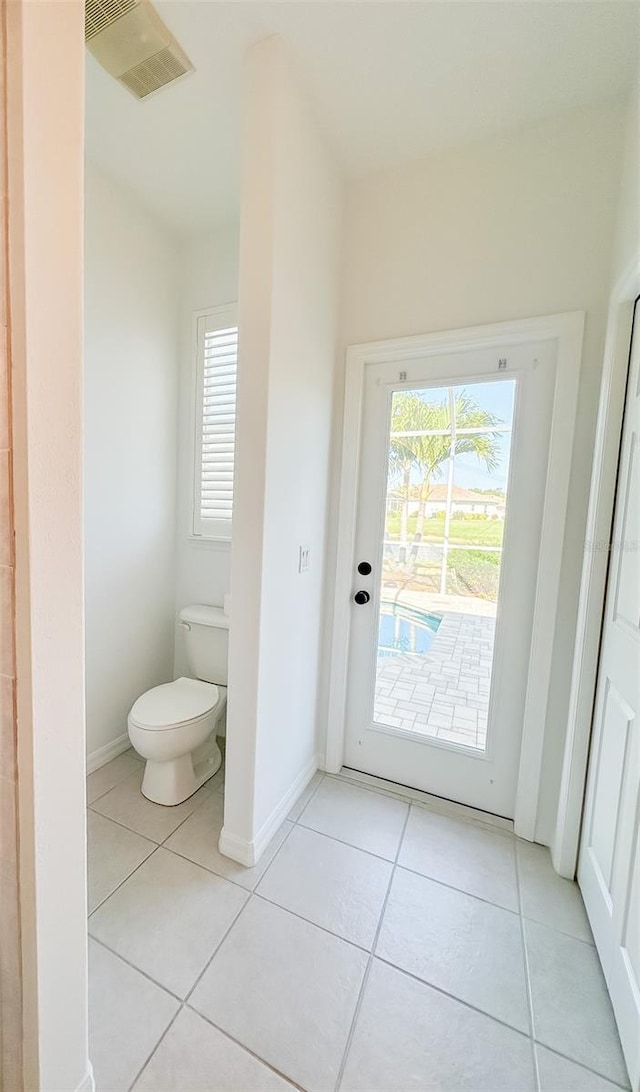 bathroom with toilet, tile patterned flooring, visible vents, and baseboards