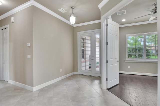 entrance foyer with tile flooring, ceiling fan, and crown molding