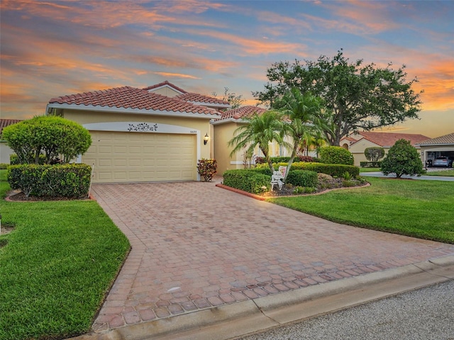 mediterranean / spanish home featuring a lawn and a garage