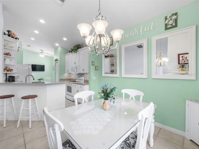 dining room with light tile patterned floors and ceiling fan with notable chandelier