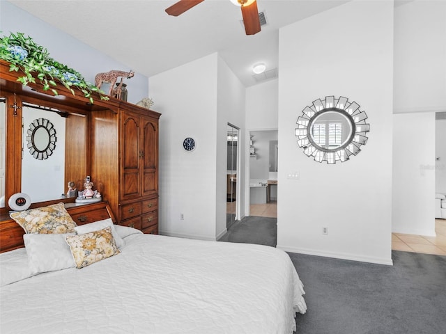 carpeted bedroom with connected bathroom, high vaulted ceiling, and ceiling fan