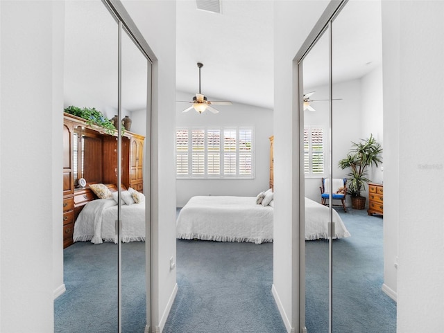 carpeted bedroom with multiple closets, lofted ceiling, and ceiling fan