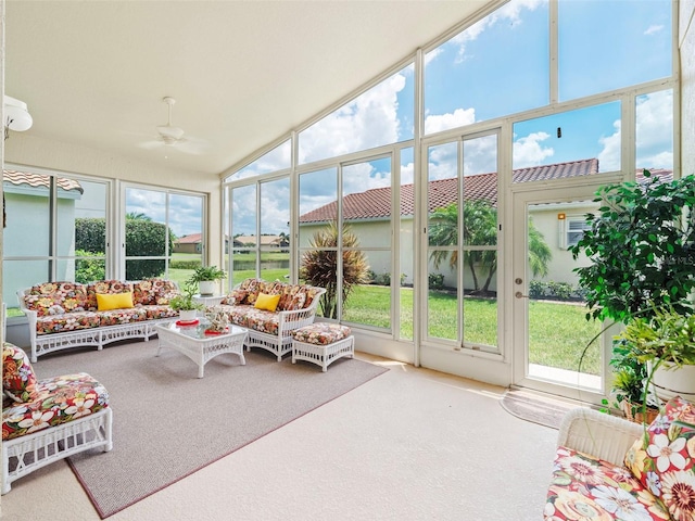 sunroom / solarium with ceiling fan, plenty of natural light, and vaulted ceiling