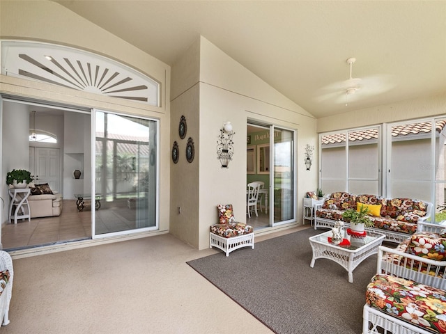 carpeted living room with ceiling fan and lofted ceiling