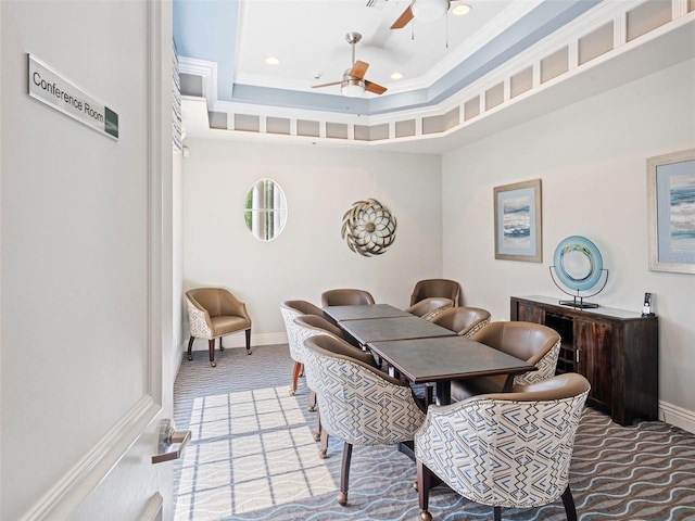 carpeted dining area featuring a tray ceiling, ceiling fan, and crown molding